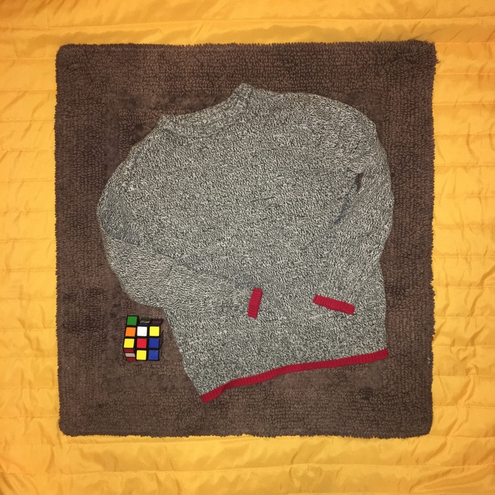 Heathered grey sweater with red trim.